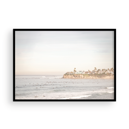 Landscape San Diego beach print of Tourmaline Beach, Pacific Beach, San Diego, showing a large group of surfers in the water near a residential cliff. This surf vibes print captures the local surf scene. Photograph in minimalist mock up.