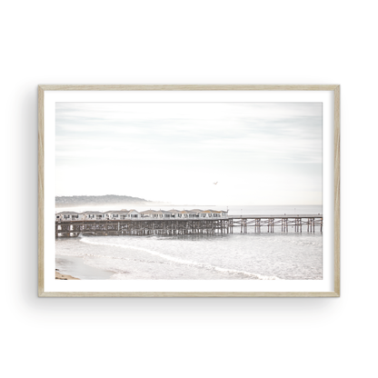 Landscape coastal photography of Crystal Pier in Pacific Beach, San Diego, extending into the calm ocean with gentle waves. Photograph in minimalist mock up