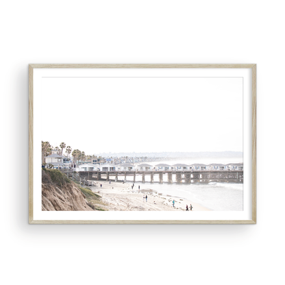 Landscape San Diego beach print of Pacific Beach's Crystal Pier, featuring its unique houses extending over the water, with people on the sandy shore. This iconic beach print is great for beach decor. Photograph in minimalist mock up.