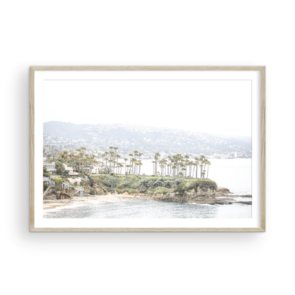 Horizontal coastal photography of Laguna Beach, San Diego, featuring a fine art giclee print featuring palm trees on a small island in a body of water. Photograph in minimalist mock up.