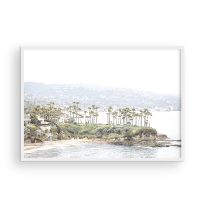 Horizontal coastal photography of Laguna Beach, San Diego, featuring a fine art giclee print featuring palm trees on a small island in a body of water. Photograph in minimalist mock up.
