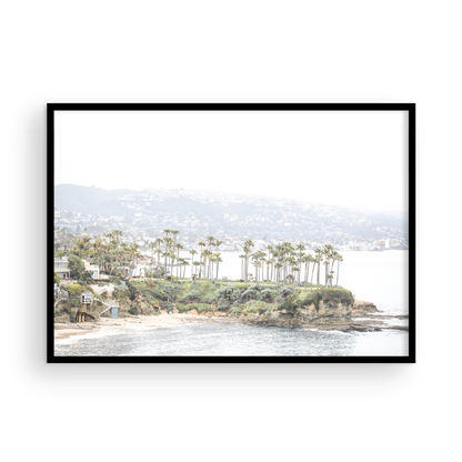 Horizontal coastal photography of Laguna Beach, San Diego, featuring a fine art giclee print featuring palm trees on a small island in a body of water. Photograph in minimalist mock up.