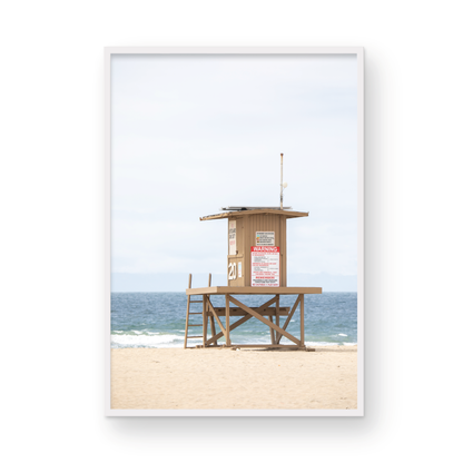 A wide landscape coastal photography view of Newport Beach in Southern California, featuring a lifeguard tower and walls on the beach. Photograph in minimalist mock up.
