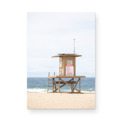 A wide landscape coastal photography view of Newport Beach in Southern California, featuring a lifeguard tower and walls on the beach. Photograph in minimalist mock up.