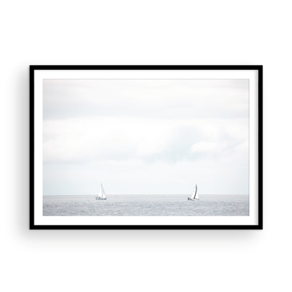 Minimalist ocean print featuring two sailboats on a calm ocean under a vast, bright sky. This serene seascape is ideal for coastal, nautical theme wall art. Photograph in minimalist mock up