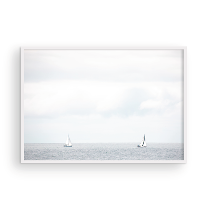 Minimalist ocean print featuring two sailboats on a calm ocean under a vast, bright sky. This serene seascape is ideal for coastal, nautical theme wall art. Photograph in minimalist mock up