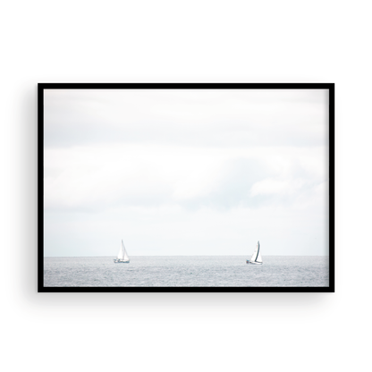 Minimalist ocean print featuring two sailboats on a calm ocean under a vast, bright sky. This serene seascape is ideal for coastal, nautical theme wall art. Photograph in minimalist mock up