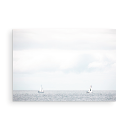 Minimalist ocean print featuring two sailboats on a calm ocean under a vast, bright sky. This serene seascape is ideal for coastal, nautical theme wall art. Photograph in minimalist mock up