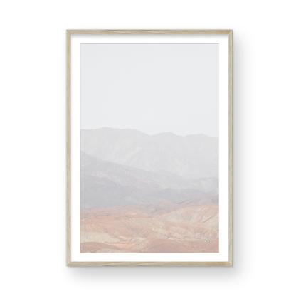 Minimalist art print of hazy mountains layered in soft tones, creating a calm ocean print aesthetic. This vertical minimalist art print can fit a neutral ocean print theme. Photograph in minimalist mock up.