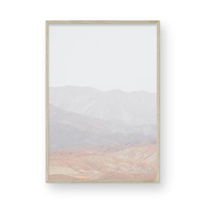 Minimalist art print of hazy mountains layered in soft tones, creating a calm ocean print aesthetic. This vertical minimalist art print can fit a neutral ocean print theme. Photograph in minimalist mock up.