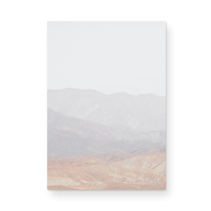 Minimalist art print of hazy mountains layered in soft tones, creating a calm ocean print aesthetic. This vertical minimalist art print can fit a neutral ocean print theme. Photograph in minimalist mock up.