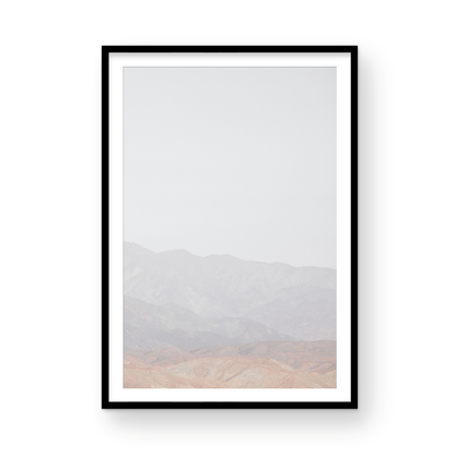 Minimalist art print of hazy mountains layered in soft tones, creating a calm ocean print aesthetic. This vertical minimalist art print can fit a neutral ocean print theme. Photograph in minimalist mock up.