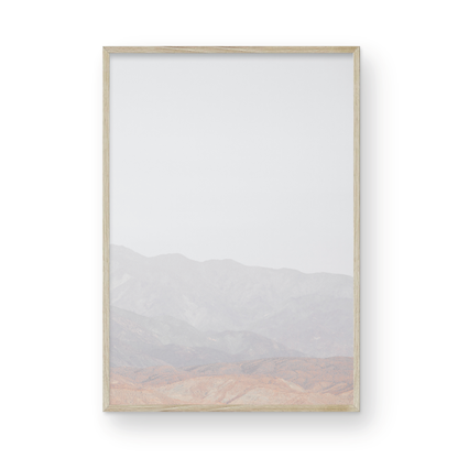 Minimalist art print of hazy mountains layered in soft tones, creating a calm ocean print aesthetic. This vertical minimalist art print can fit a neutral ocean print theme. Photograph in minimalist mock up.