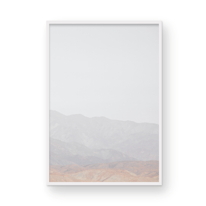 Minimalist art print of hazy mountains layered in soft tones, creating a calm ocean print aesthetic. This vertical minimalist art print can fit a neutral ocean print theme. Photograph in minimalist mock up.