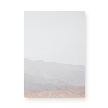 Minimalist art print of hazy mountains layered in soft tones, creating a calm ocean print aesthetic. This vertical minimalist art print can fit a neutral ocean print theme. Photograph in minimalist mock up.