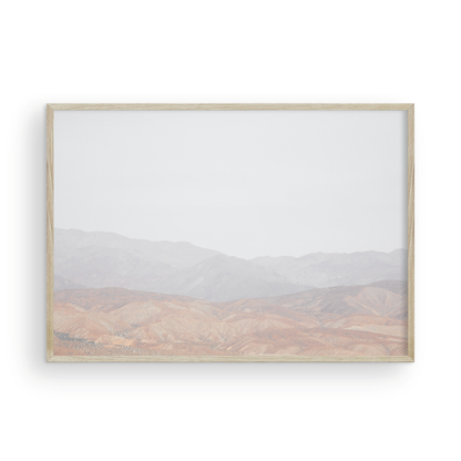 Minimalist art print of hazy mountains layered in soft tones, creating a calm ocean print aesthetic. This horizontal minimalist art print can fit a neutral ocean print theme. Photograph in minimalist mock up.