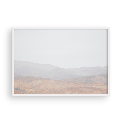 Minimalist art print of hazy mountains layered in soft tones, creating a calm ocean print aesthetic. This horizontal minimalist art print can fit a neutral ocean print theme. Photograph in minimalist mock up.