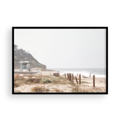 Landscape coastal photography of a light-colored lifeguard tower at a Southern California beach, with a rustic wooden fence leading towards the ocean waves. This tranquil beachscape print is ideal for beach cottage wall decor or a calm beach print. Photograph in minimalist mock up.