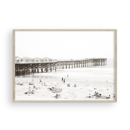 Sepia beach photo of Crystal Pier in Pacific Beach, San Diego, with people on the sandy beach. This framed coastal print showcases iconic beach scenes. Photograph in minimalist mock up.