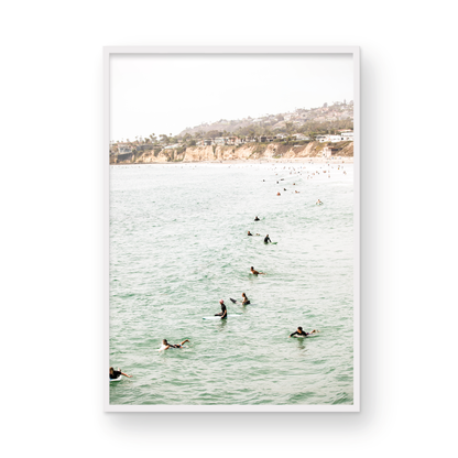 Vertical surf print showing several surfers paddling in the ocean at Pacific Beach, with a distant coastline. This image captures the surfing art of Southern California. Photograph in minimalist mock up.