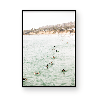 Vertical surf print showing several surfers paddling in the ocean at Pacific Beach, with a distant coastline. This image captures the surfing art of Southern California. Photograph in minimalist mock up.