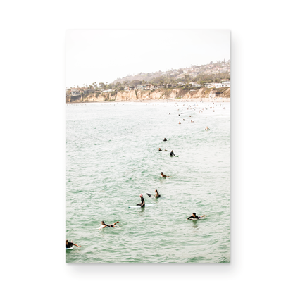 Vertical surf print showing several surfers paddling in the ocean at Pacific Beach, with a distant coastline. This image captures the surfing art of Southern California. Photograph in minimalist mock up.