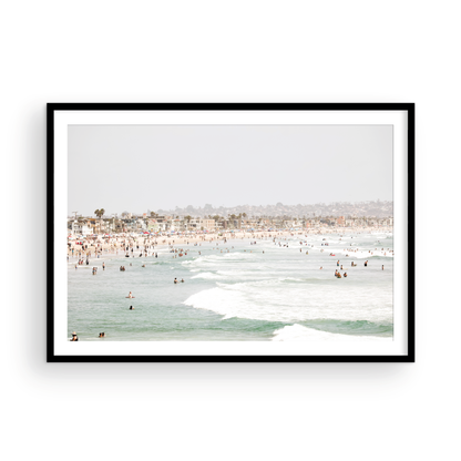 Landscape beach photography of a busy San Diego public beach with many people in the sand and ocean waves, a true summer vibes scene. Photograph in minimalist mock up.