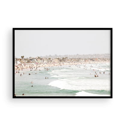 Landscape beach photography of a busy San Diego public beach with many people in the sand and ocean waves, a true summer vibes scene. Photograph in minimalist mock up.
