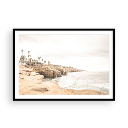 Fine art of Sunset Cliffs, San Diego California horizontal print of hazy high-angle landscape beach photography captures a light blue ocean meeting tall tan, brown cliffs rise as iconic coastal scenery. Photograph in minimalist mock up.
