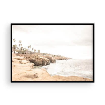 Fine art of Sunset Cliffs, San Diego California horizontal print of hazy high-angle landscape beach photography captures a light blue ocean meeting tall tan, brown cliffs rise as iconic coastal scenery. Photograph in minimalist mock up.