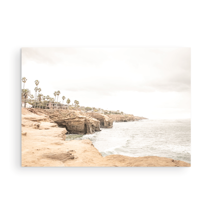 Fine art of Sunset Cliffs, San Diego California horizontal print of hazy high-angle landscape beach photography captures a light blue ocean meeting tall tan, brown cliffs rise as iconic coastal scenery. Photograph in minimalist mock up.