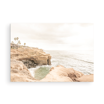 Fine art of Sunset Cliffs, San Diego California horizontal print of hazy high-angle landscape beach photography captures a light blue ocean meeting tall tan, rocky, brown cliffs rise as iconic coastal scenery. Photograph in minimalist mock up.