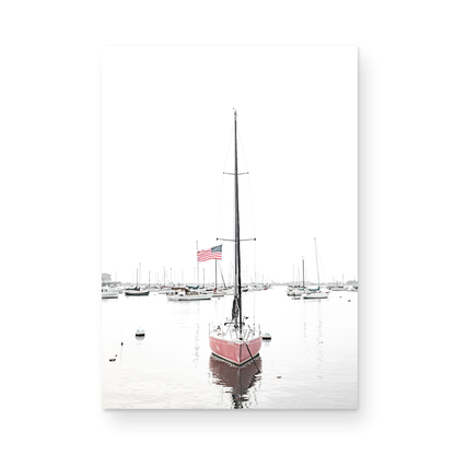 A vertical San Diego print featuring a lone red sailboat with an American flag, anchored in a calm San Diego harbor. This minimalist ocean print captures the essence of coastal photography and is perfect for modern coastal decor. Photograph in minimalist mock up.