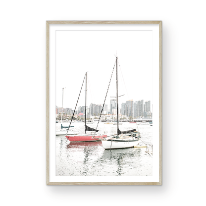 A vertical San Diego print showcasing numerous sailboats in San Diego Harbor with the city skyline in the background. This modern coastal print embodies the Southern California coastal photography, perfect for a large beach wall art. Photograph in minimalist mock up.