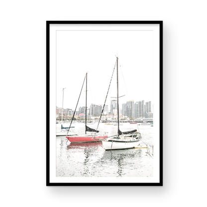 A vertical San Diego print showcasing numerous sailboats in San Diego Harbor with the city skyline in the background. This modern coastal print embodies the Southern California coastal photography, perfect for a large beach wall art. Photograph in minimalist mock up.
