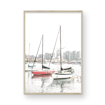 A vertical San Diego print showcasing numerous sailboats in San Diego Harbor with the city skyline in the background. This modern coastal print embodies the Southern California coastal photography, perfect for a large beach wall art. Photograph in minimalist mock up.