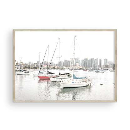 A horizontal San Diego print showcasing numerous sailboats in San Diego Harbor with the city skyline in the background. This modern coastal print embodies the Southern California coastal photography, perfect for a large beach wall art. Photograph in minimalist mock up.