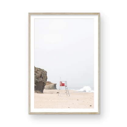 Vertical coastal photography featuring a red and white lifeguard chair and a calm ocean background, located in Laguna California. Photograph in minimalist mock up.