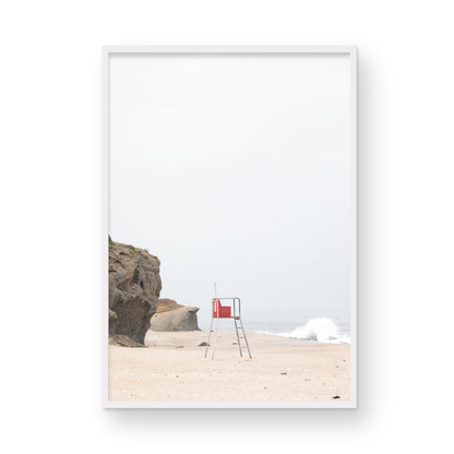 Vertical coastal photography featuring a red and white lifeguard chair and a calm ocean background, located in Laguna California. Photograph in minimalist mock up.