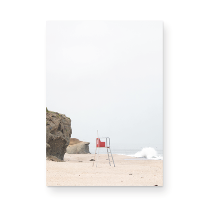 Vertical coastal photography featuring a red and white lifeguard chair and a calm ocean background, located in Laguna California. Photograph in minimalist mock up.