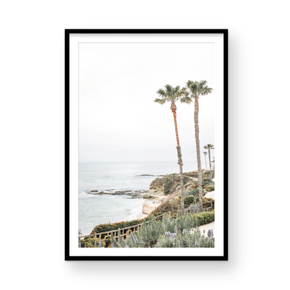 Vertical coastal photography featuring a scenic view of the ocean with palm trees in the background, set against a white sky, located in Laguna California. Photograph in minimalist mock up.