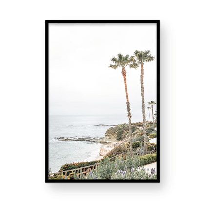 Vertical coastal photography featuring a scenic view of the ocean with palm trees in the background, set against a white sky, located in Laguna California. Photograph in minimalist mock up.
