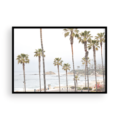 Horizontal coastal photography of a beachscape at Laguna Beach, California, beach art print featuring palm trees and a clear blue sky with a few clouds over a beach scene. Photograph in minimalist mock up.