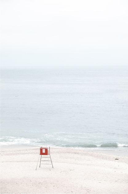 Vertical coastal photography featuring a red and white lifeguard chair and a calm ocean background, located in Laguna California. 