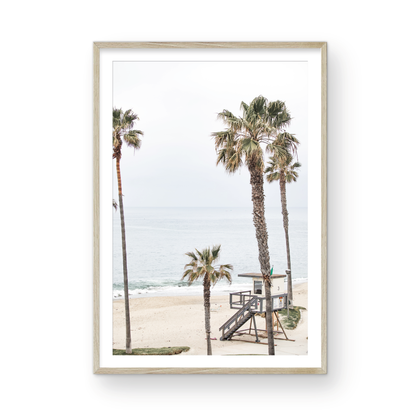 Vertical coastal photography of a coastal scene with palm trees and a lifeguard tower at Aliso Beach, Laguna California, with a wooden frame. Photograph in minimalist mock up.