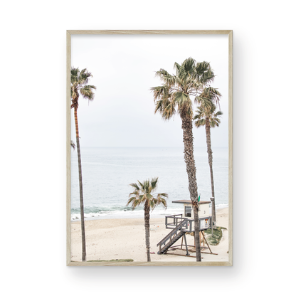 Vertical coastal photography of a coastal scene with palm trees and a lifeguard tower at Aliso Beach, Laguna California, with a wooden frame. Photograph in minimalist mock up.