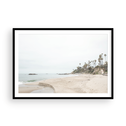 Horizontal coastal photography of a white lifeguard tower at Laguna Beach, California, depicting a beach scene with palm trees and a calm ocean. Photograph in minimalist mock up.