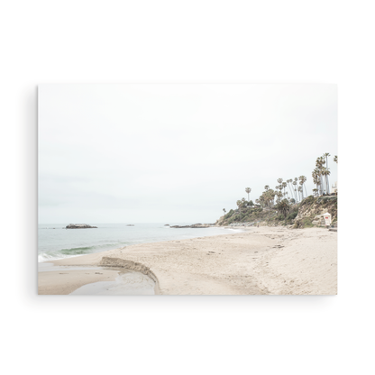 Horizontal coastal photography of a white lifeguard tower at Laguna Beach, California, depicting a beach scene with palm trees and a calm ocean. Photograph in minimalist mock up.