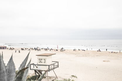 Landscape beach photography of Salt Creek Beach, with lifeguard tower SC 3 in the foreground, and many people enjoying the beach and ocean in the distance. A beach vibes print. 