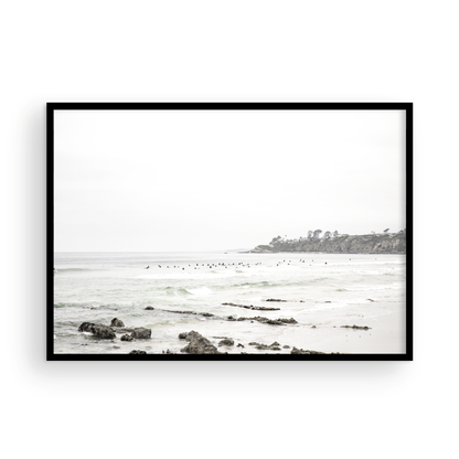 Landscape coastal photography of Salt Creek Beach with dark rocks on the shore and numerous surfers in the ocean. A neutral ocean print perfect for beach house decor. Photograph in minimalist mock up.